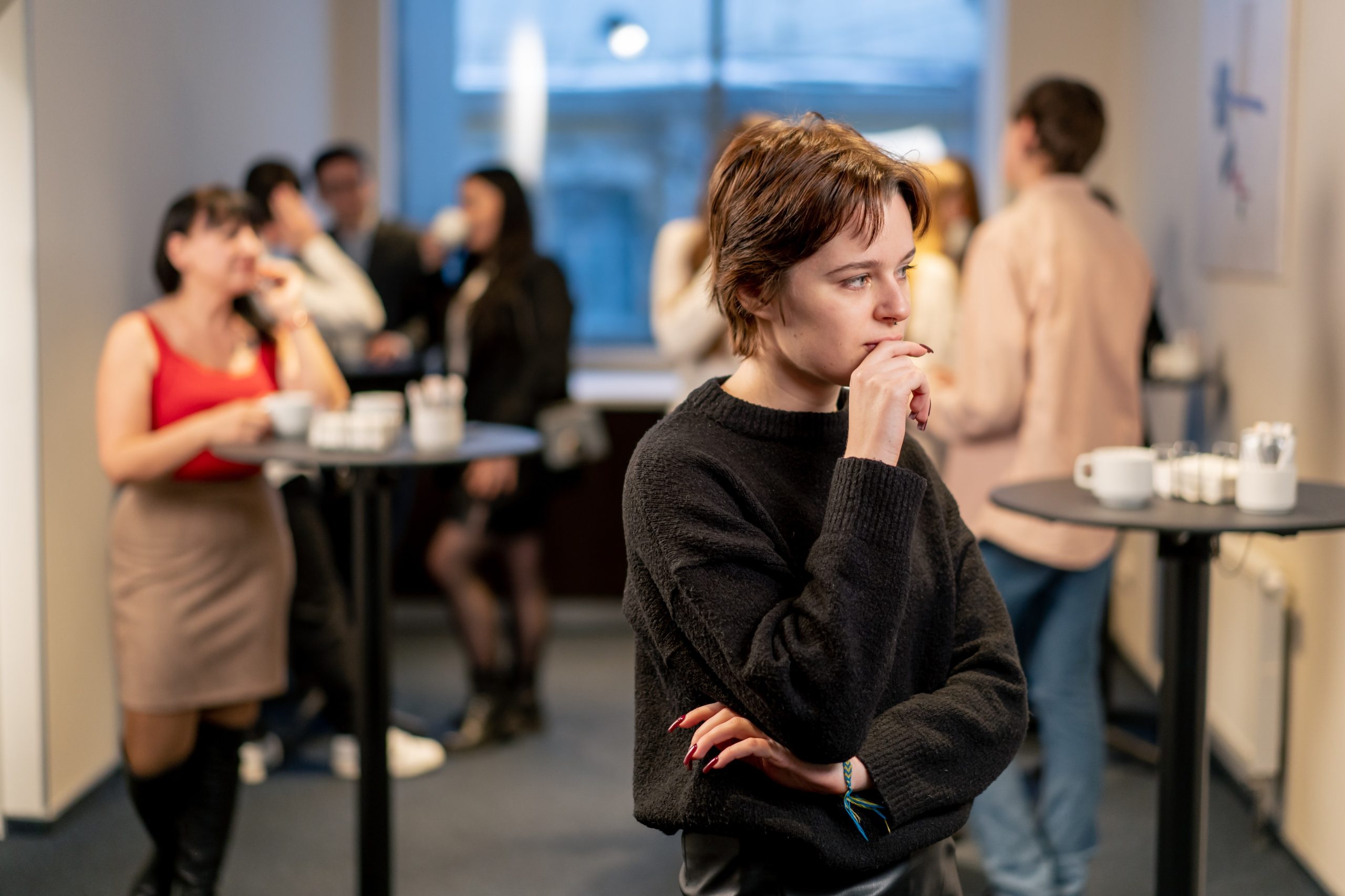 Shy person standing apart at a group meetup — why some people prefer a 1-on-1 Meetup Alternative in Berlin