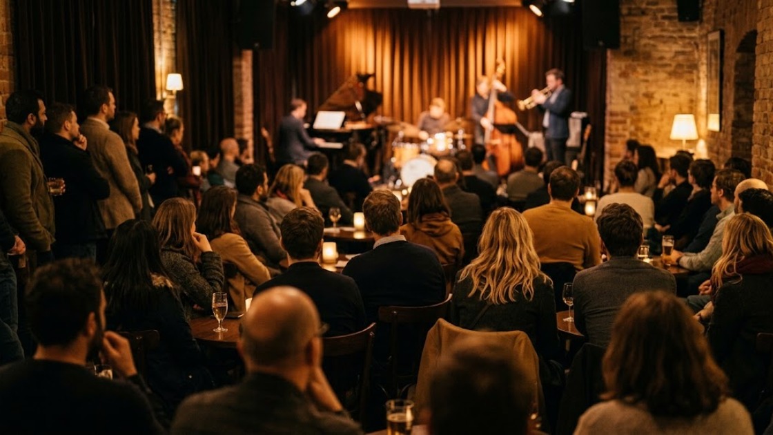 An audience listening to a band in a small candlelit jazz club