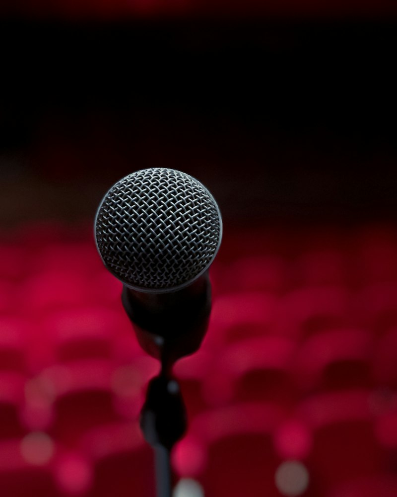 A microphone on stage in front of red theatre seats