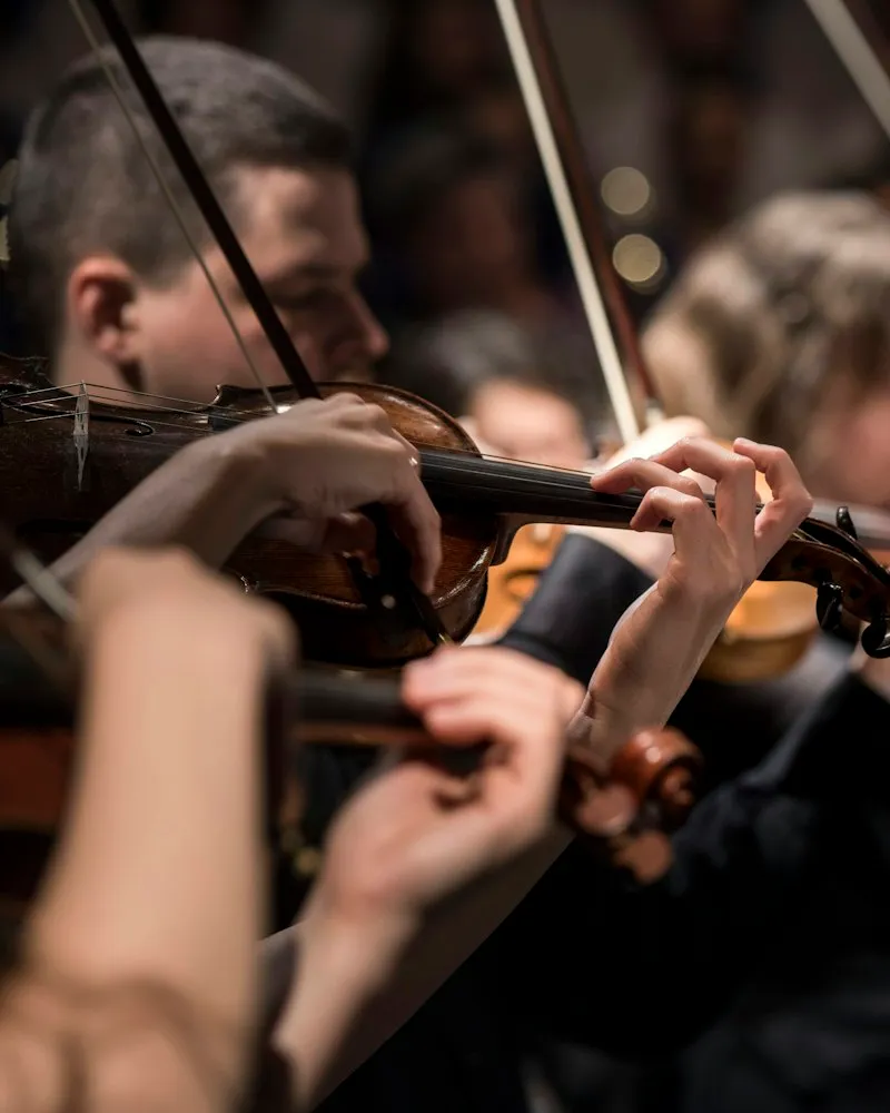 Violinists playing in warm, dim light