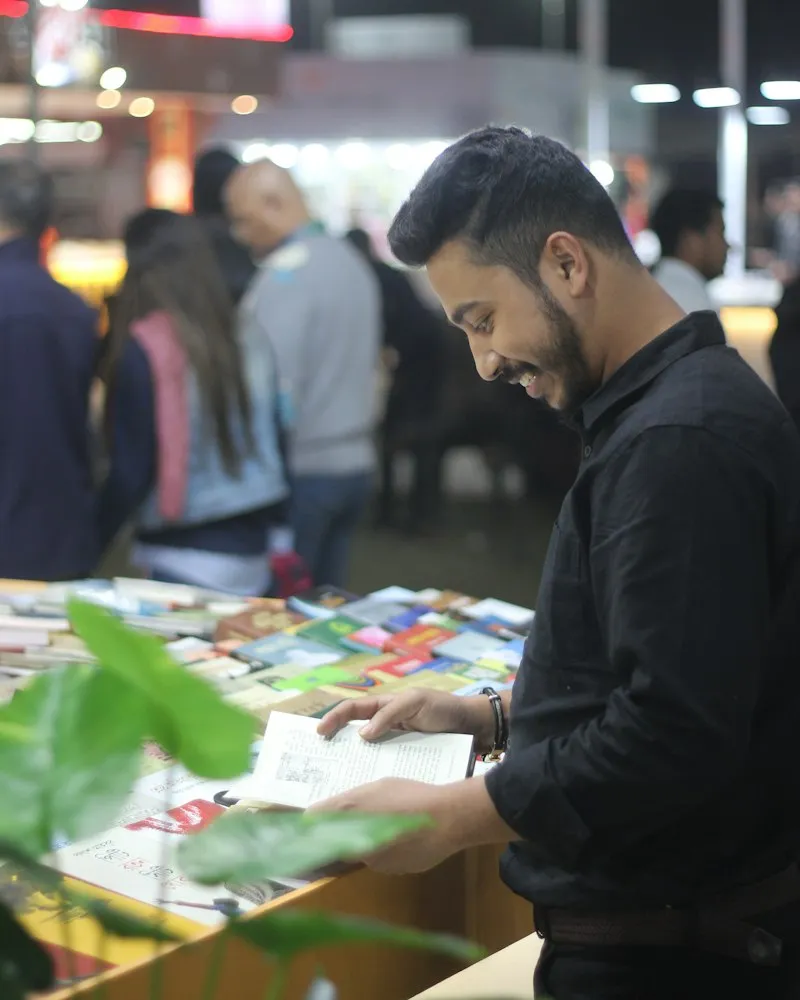 A visitor browsing prints and zines at a fair table